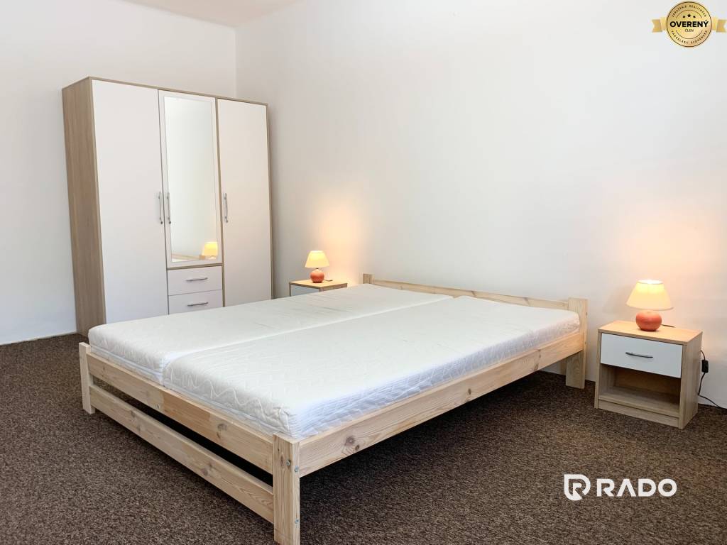 Spálňa v 2-izbovom byte s manželskou posteľou, 2 nočnými stolíkmi, 2 nočnými lampami a skriňou